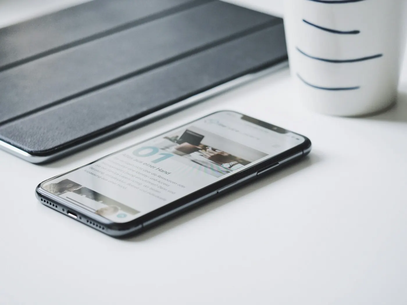 白い机に置かれたスマートフォンとタブレット